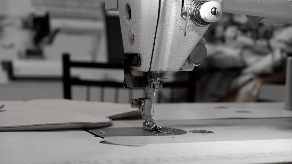 bernina - Closeup of an industrial sewing machine in a textile factory, focused on needle and fabric