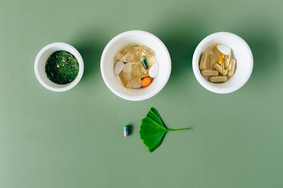 tisso - Flatlay of capsules and herbs in ceramic bowls on green surface.