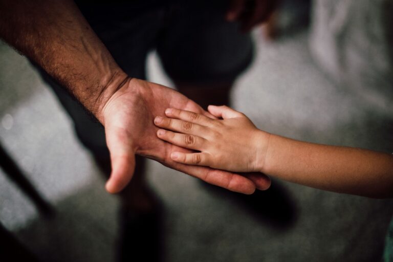 Hände von Vater und Kind als Symbol für Vaterschaft