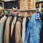 walbusch solingen - A vibrant assortment of vintage jackets hanging on a wooden rack in a boutique.