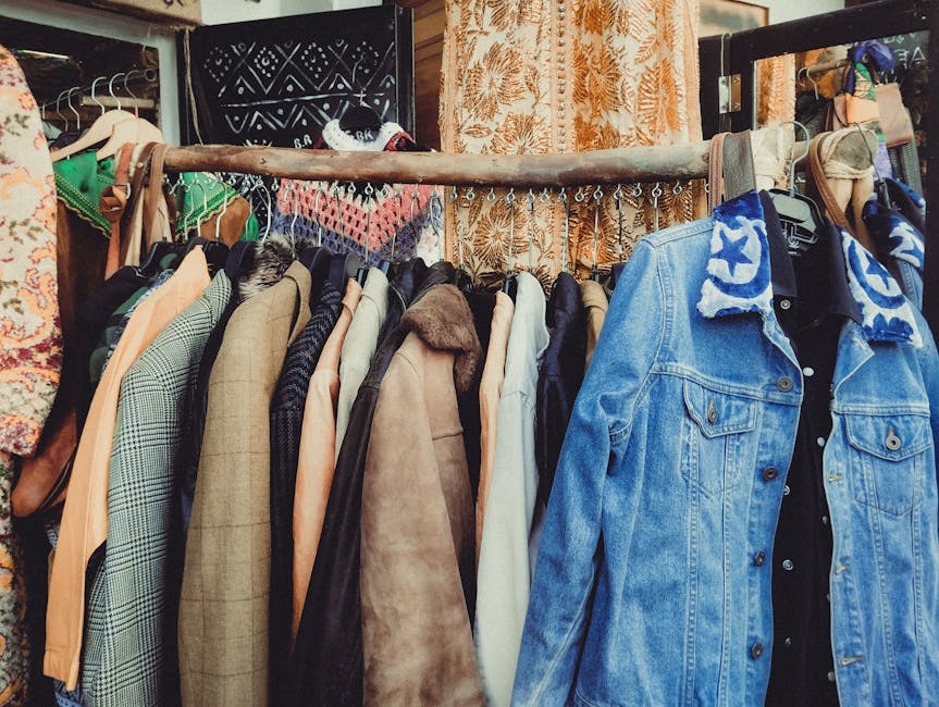 walbusch solingen - A vibrant assortment of vintage jackets hanging on a wooden rack in a boutique.