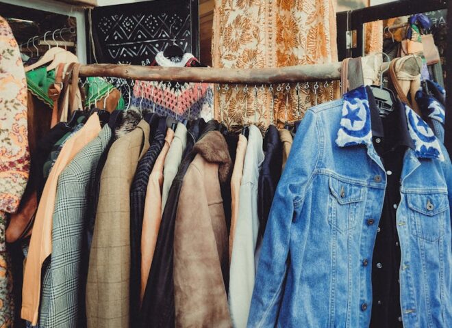 walbusch solingen - A vibrant assortment of vintage jackets hanging on a wooden rack in a boutique.